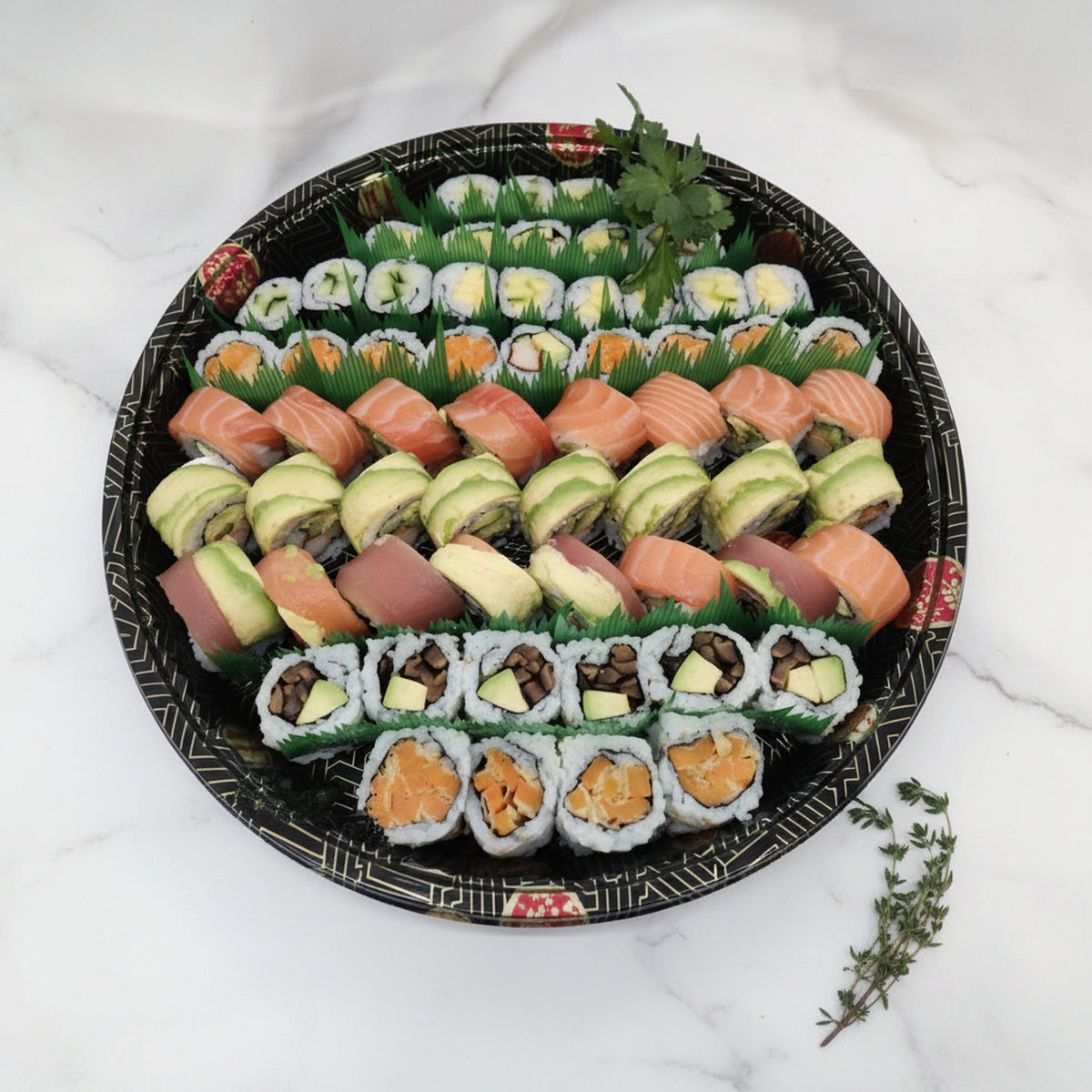 Overhead view of a 36 piece small maki platter on a black catering tray on a marble surface