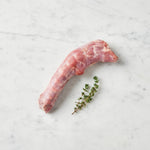 Raw duck neck with a thyme sprig on white marble