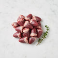 Raw chicken giblets on a white marble surface