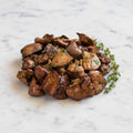 Cooked Chicken Liver pieces with sauteed onion, parsley and thyme on a marble surface