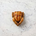 Overhead view of a whole cooked Cornish Hen with golden roasted skin on a marble surface