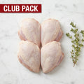 Club Pack of four raw bone-in, skin-on chicken breasts with thyme on white marble