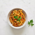Overhead view of a bowl of Penne in Tomato Sauce garnished with parsley