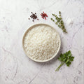 Overhead view of a bowl of plain white rice on a marble surface