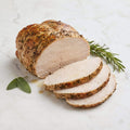 Roast Turkey Breast, partly sliced, with herb crust, rosemary and sage on a marble surface