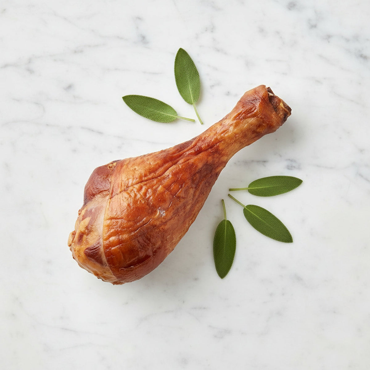 A Smoked Turkey Drumstick with glossy mahogany skin and sage leaves on a marble surface