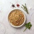 Overhead view of a bowl of TK Asian Noodles with bean sprouts, carrot and scallion on a marble surface