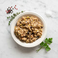 Overhead view of a bowl of TK Charoses, chopped apple and nuts, on a marble surface