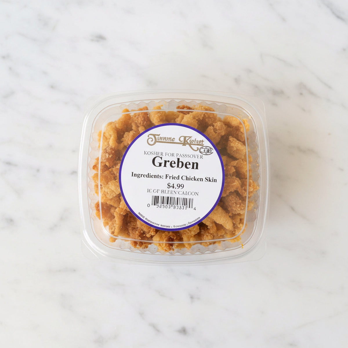 Overhead view of a container of TK Greben, fried chicken skin, on a marble surface