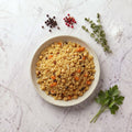 Overhead view of a bowl of TK Moroccan Couscous with chickpeas, carrot, raisins and slivered almonds