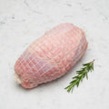 TK turkey roll of dark and white meat on a white marble surface