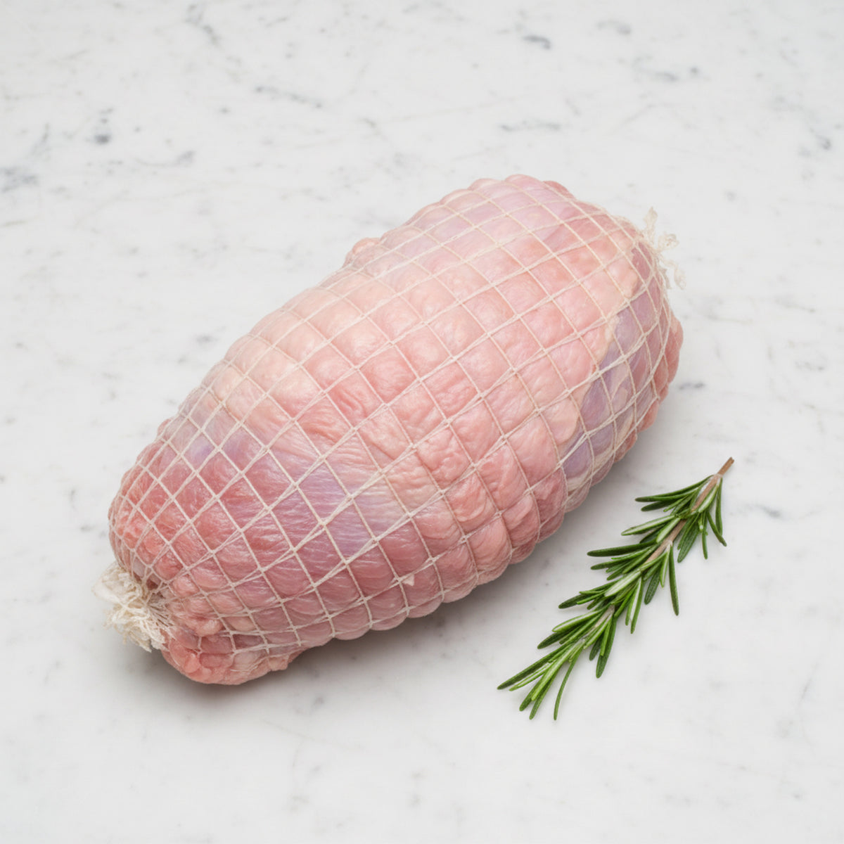 TK turkey roll of dark and white meat on a white marble surface