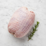 TK white meat turkey roll on a white marble surface