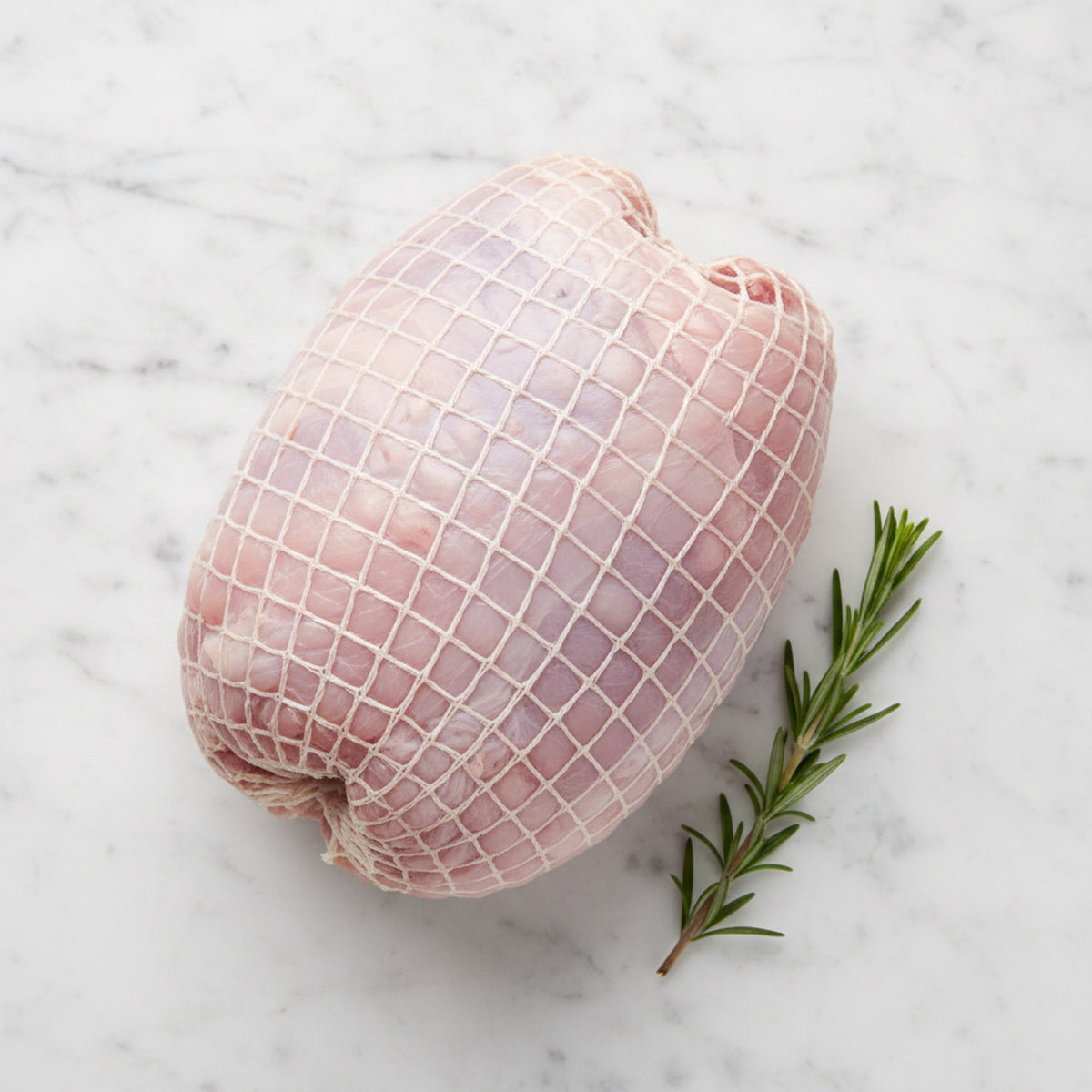 TK white meat turkey roll on a white marble surface
