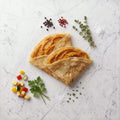 Overhead view of two folded Yam Crepes filled with sweet potato puree on a marble surface